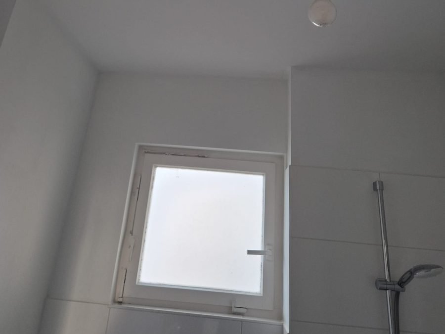 Badezimmer mit erneuerter Deckenleuchte und Fenster